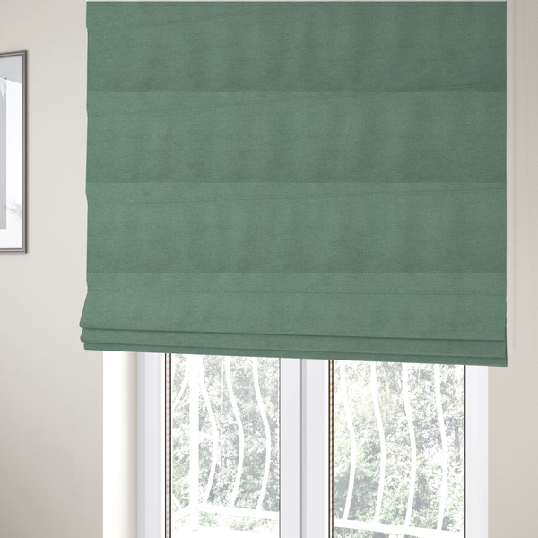 The fabric used to create these Roman blinds is a textured sage or mint green fabric with a tight, uniform weave.