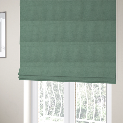 The fabric used to create these Roman blinds is a textured sage or mint green fabric with a tight, uniform weave.
