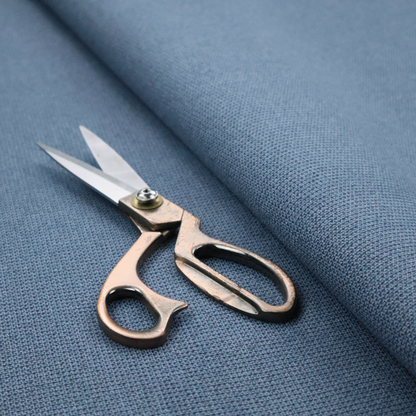A textured denim blue fabric with a tight, uniform cross-weave pattern.