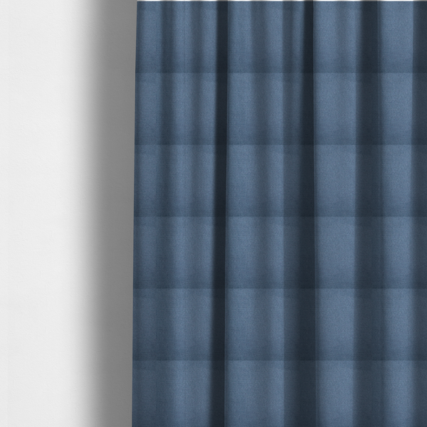 The fabric used to create these made-to-measure curtains is a textured denim blue fabric with a tight, uniform cross-weave pattern.
