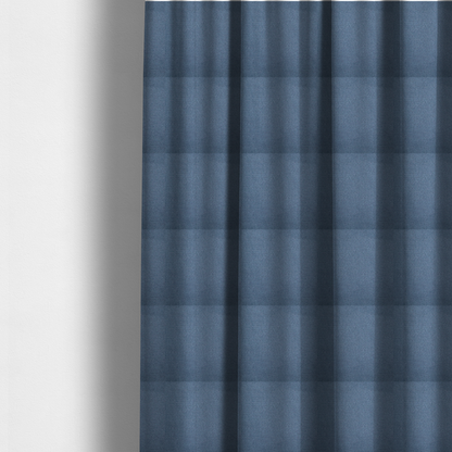 The fabric used to create these made-to-measure curtains is a textured denim blue fabric with a tight, uniform cross-weave pattern.