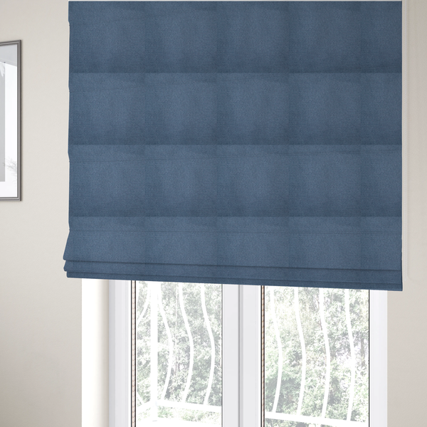 The fabric used to create these Roman blinds is a textured denim blue fabric with a tight, uniform cross-weave pattern.