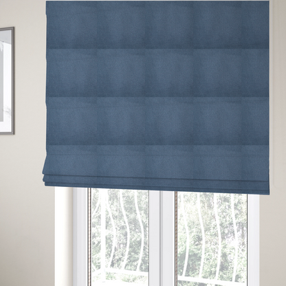 The fabric used to create these Roman blinds is a textured denim blue fabric with a tight, uniform cross-weave pattern.