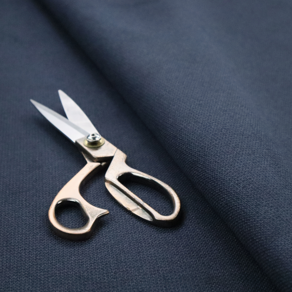 A textured navy blue fabric with a tight, uniform cross-weave pattern.