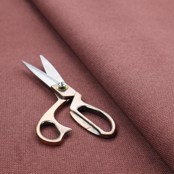 A textured terracotta pink fabric with a tight, uniform cross-weave.