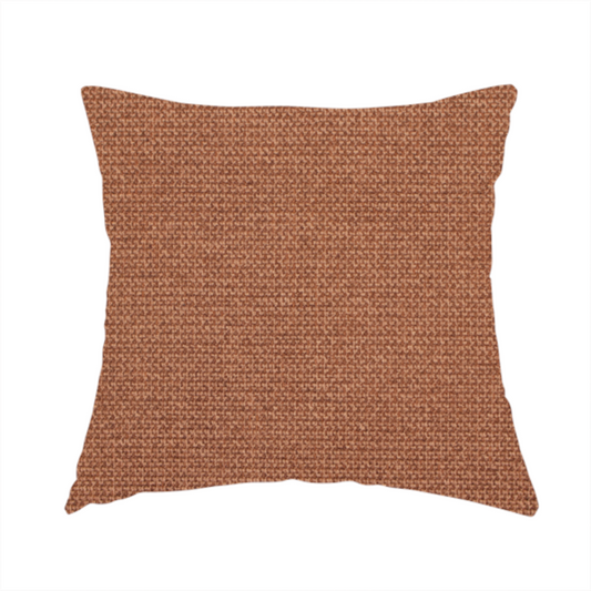 The fabric used to create this handmade cushion is a textured terracotta orange fabric with a tight, uniform weave.