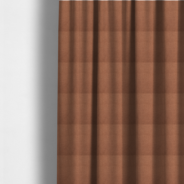 The fabric used to create these made-to-measure curtains is a textured terracotta orange fabric with a tight, uniform weave.
