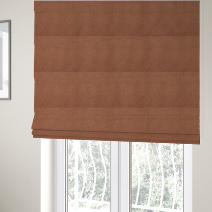 The fabric used to create these Roman blinds is a textured terracotta orange fabric with a tight, uniform weave.