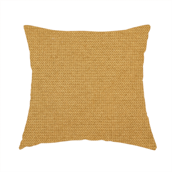 The fabric used to create this handmade cushion is a textured mustard yellow fabric with a tight, uniform weave.
