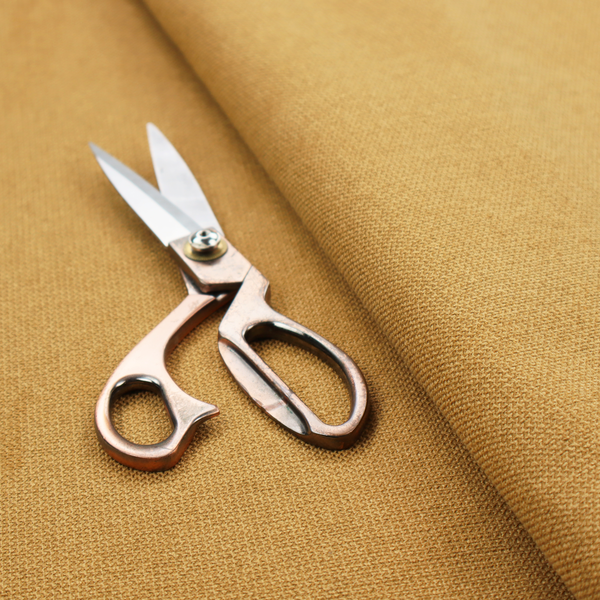 A textured mustard yellow fabric with a tight, uniform weave.