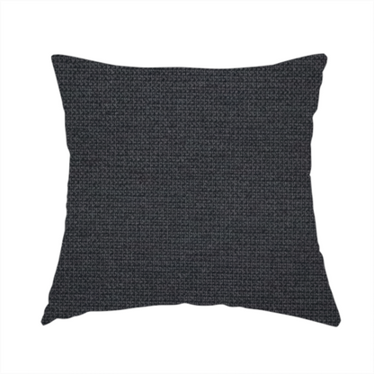 The fabric used to create this handmade cushion is a textured near-black fabric with a tight, uniform cross-weave.