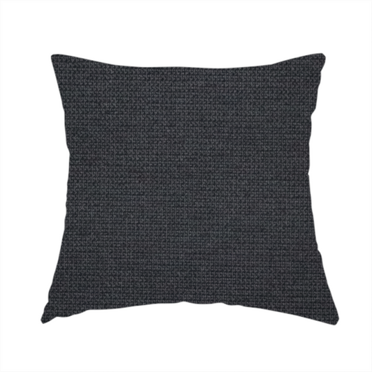 The fabric used to create this handmade cushion is a textured near-black fabric with a tight, uniform cross-weave.
