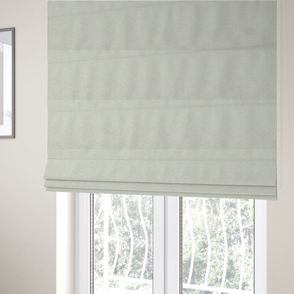 The fabric used to create these Roman blinds is a textured cream and off-white woven fabric.