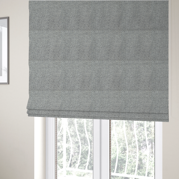 The fabric used to create these Roman blinds is a textured mid-grey and off-white woven fabric.