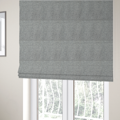 The fabric used to create these Roman blinds is a textured mid-grey and off-white woven fabric.