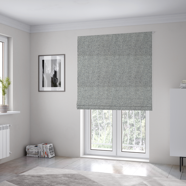 The fabric used to create these Roman blinds is a textured mid-grey and off-white woven fabric.