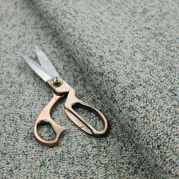 A multi-tonal teal and grey textured woven fabric swatch.