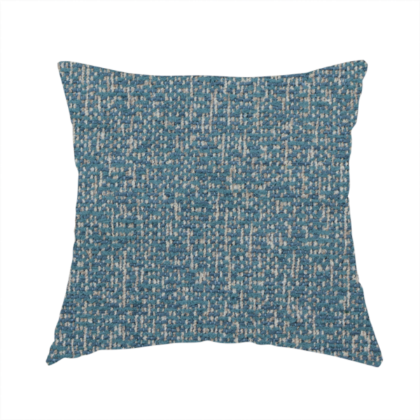 The fabric used to create this handmade cushion is a multi-tonal blue and beige textured woven fabric swatch.