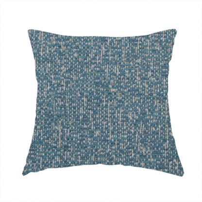The fabric used to create this handmade cushion is a multi-tonal blue and beige textured woven fabric swatch.