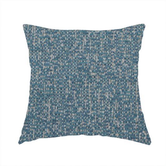 The fabric used to create this handmade cushion is a multi-tonal blue and beige textured woven fabric swatch.
