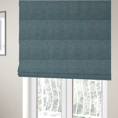 The fabric used to create these Roman blinds is a multi-tonal blue and beige textured woven fabric swatch.