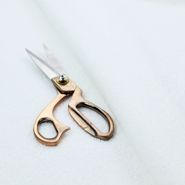 A textured white fabric with a soft, pebbled fleece or Sherpa appearance.