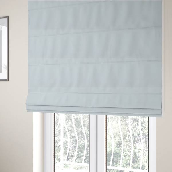 The fabric used to create these Roman blinds is a textured white fabric with a soft, pebbled fleece or Sherpa appearance.