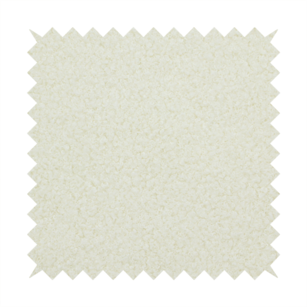 A textured cream-coloured bouclé upholstery fabric.