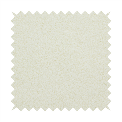 A textured cream-coloured bouclé upholstery fabric.