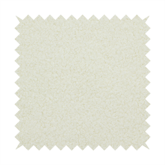 A textured cream-coloured bouclé upholstery fabric.