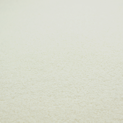 A textured cream-coloured bouclé upholstery fabric.