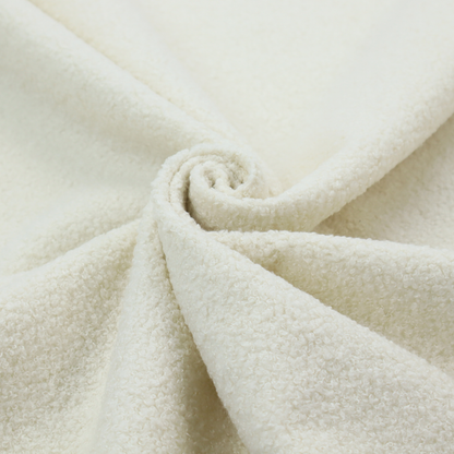 A textured cream-coloured bouclé upholstery fabric.