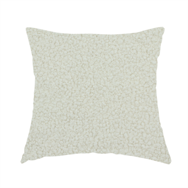 The fabric used to create this handmade cushion is a textured beige or oatmeal bouclé upholstery fabric.