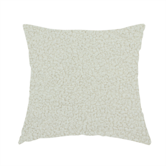 The fabric used to create this handmade cushion is a textured beige or oatmeal bouclé upholstery fabric.