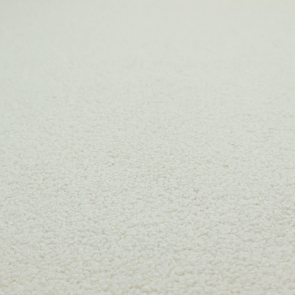 A textured beige or oatmeal bouclé upholstery fabric.