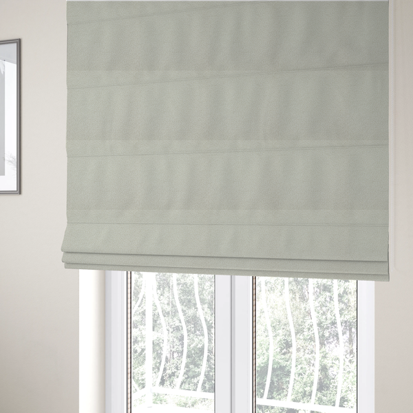 The fabric used to create these Roman blinds is a textured beige or oatmeal bouclé upholstery fabric.