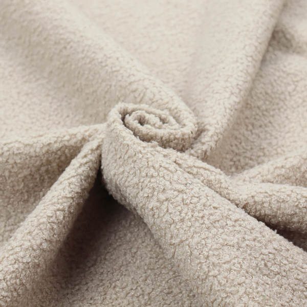 A textured beige bouclé upholstery fabric.