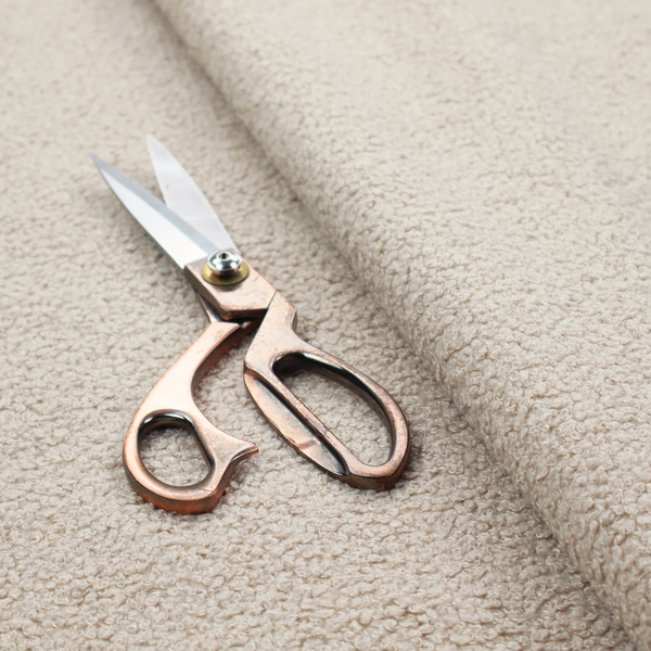 A textured beige bouclé upholstery fabric.