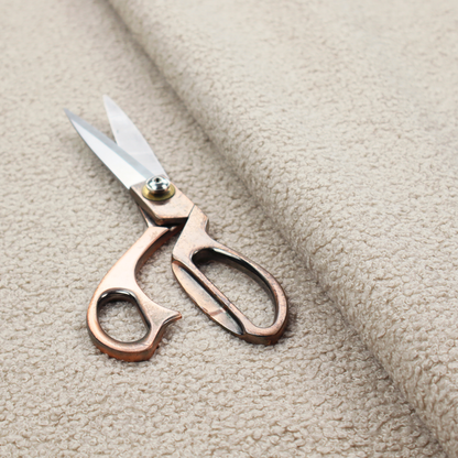 A textured beige bouclé upholstery fabric.
