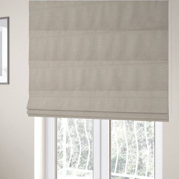 The fabric used to create these Roman blinds is a textured beige bouclé upholstery fabric.