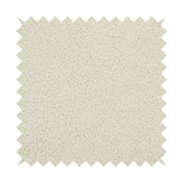 A textured ivory or light cream bouclé upholstery fabric.