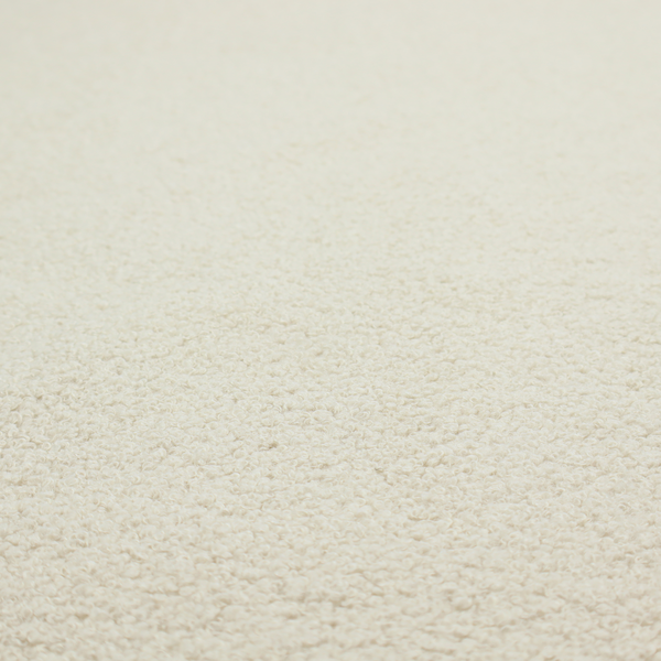 A textured ivory or light cream bouclé upholstery fabric.