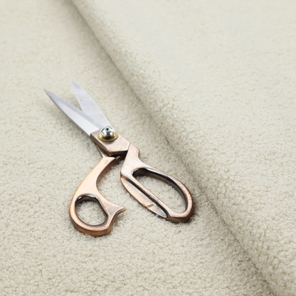 A textured ivory or light cream bouclé upholstery fabric.