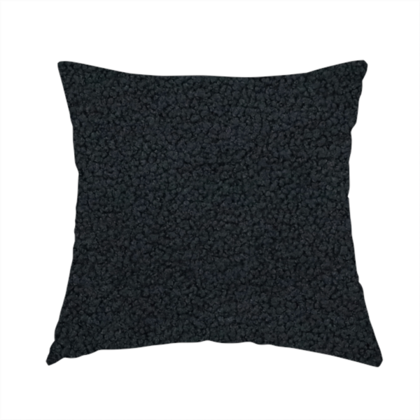 The fabric used to create this handmade cushion is a textured charcoal black bouclé upholstery fabric.