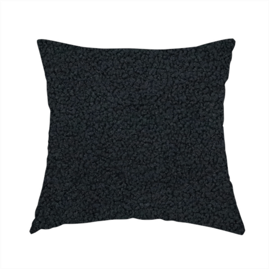 The fabric used to create this handmade cushion is a textured charcoal black bouclé upholstery fabric.