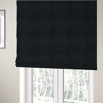 The fabric used to create these Roman blinds is a textured charcoal black bouclé upholstery fabric.