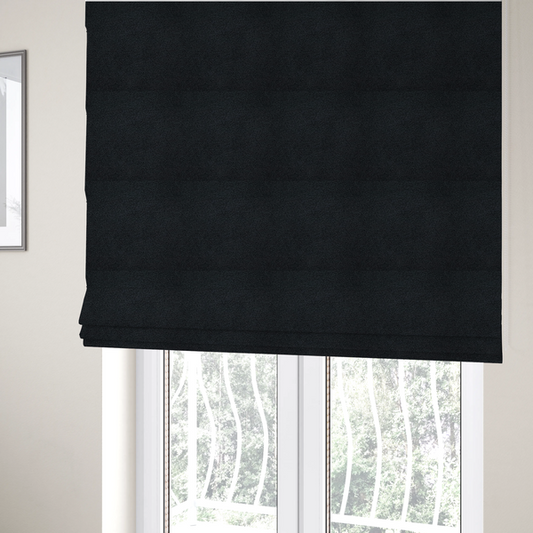 The fabric used to create these Roman blinds is a textured charcoal black bouclé upholstery fabric.