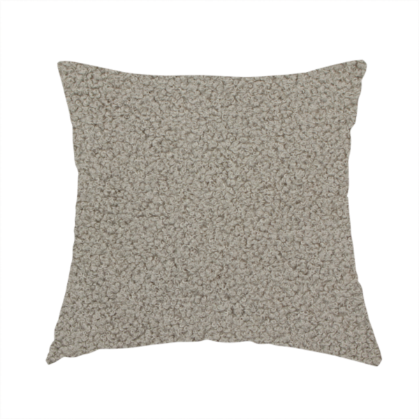 The fabric used to create this handmade cushion is a textured taupe or light grey bouclé upholstery fabric.