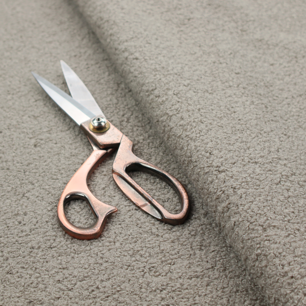 A textured taupe or light grey bouclé upholstery fabric.