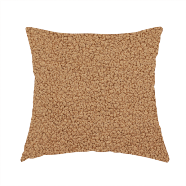 The fabric used to create this handmade cushion is a textured camel brown bouclé upholstery fabric.